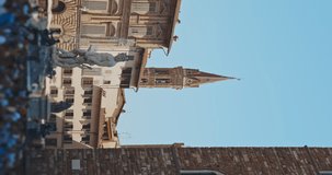 Vertical video of ancient european square with impressive fountain in the centre of it and a lot of people hurrying somewhere at sunset. Admiration of grandeur of Italian architecture.