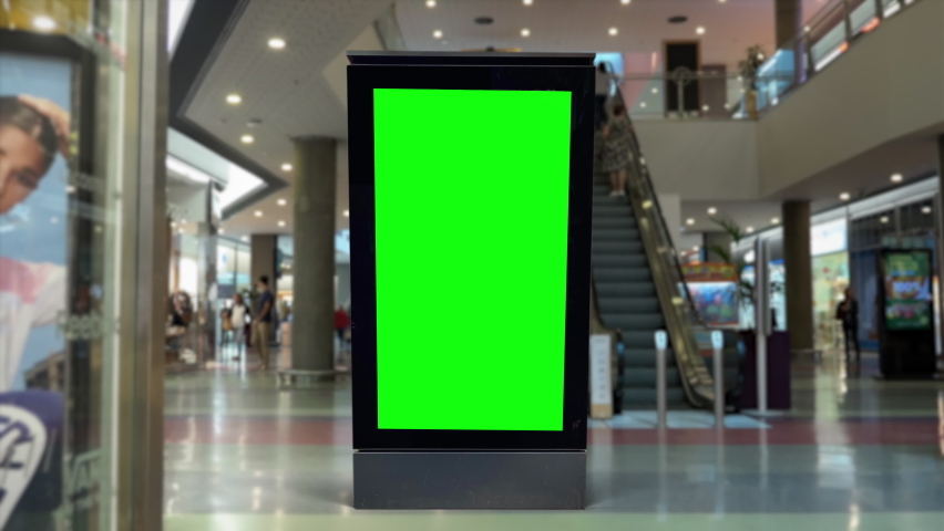 Panel Green Screen Inside Shopping Mall With People Walking. People walking behind a digital panel green screen inside a shopping mall. Royalty-Free Stock Footage #1079950319