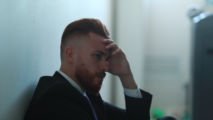 Regretful man feeling despair and isolation sitting on home floor feeling desolate