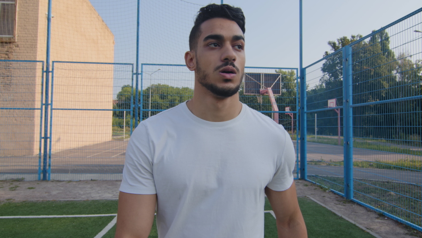 End of workout, good job. Tired Indian Middle eastern athletic man wiping sweat from forehead leaves stadium after grueling cardio. Young aspiring bodybuilder or soccer player resting after warm-up | Shutterstock HD Video #1079962079