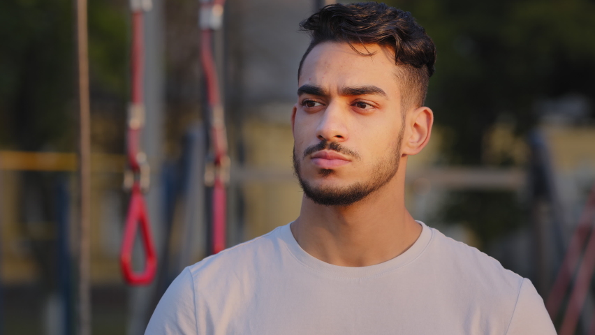 Portrait of Millennial attractive Arab man student with wide white friendly smile. Young Middle Eastern Indian mustachioed athletic guy in sportswear looking at camera posing at city stadium in summer | Shutterstock HD Video #1079962091