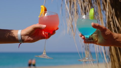 A woman and a man on the beach are drinking a cocktail. Selective focus.