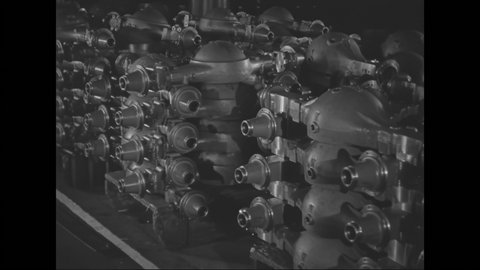 1930s: Stacks of assembled rear axles with differential covers. Worker with a forklift places another stack of completed axles.