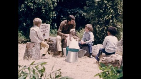 1970s: Boy looks sullen. Dennis Weaver sits on a log and talks. Boy listens then hands a box of matches to Weaver. Another boy talks. Weaver responds.