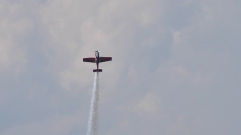Maribor Airshow Slovenia AUGUST, 15, 2021 Aerobatic plane does a loop in the sky highlighted by white smoke. MX Aircraft MXS by Veres Zoltan
