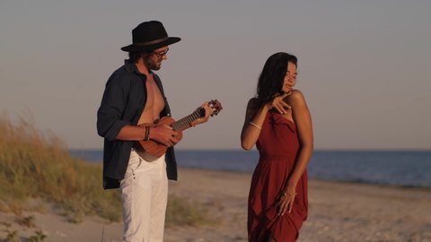 Couple in Love Playing Guitar and Dancing on the Beach