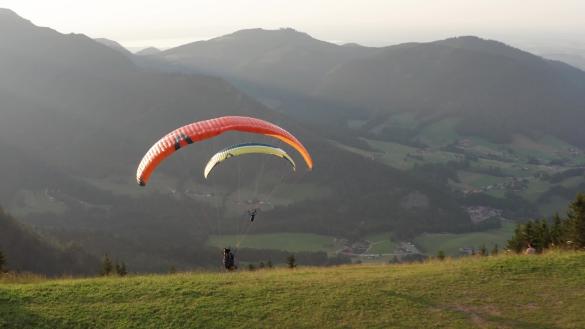 Aerial drone view following paragliders foot-launching, jumping from a hill up in the air Royalty-Free Stock Footage #1079970794