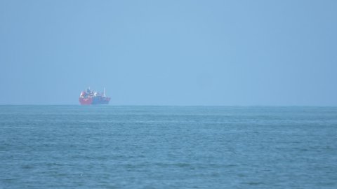 Cargo ship sailing in to the sea horizon