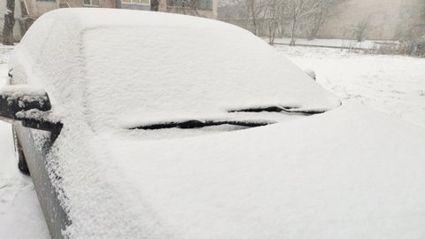 Car covered with snow on parking