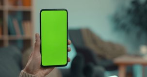 Close up of female hands holding modern smartphone with green screen during video call. Caucasian woman holding nasal spray during consultation with doctor.
