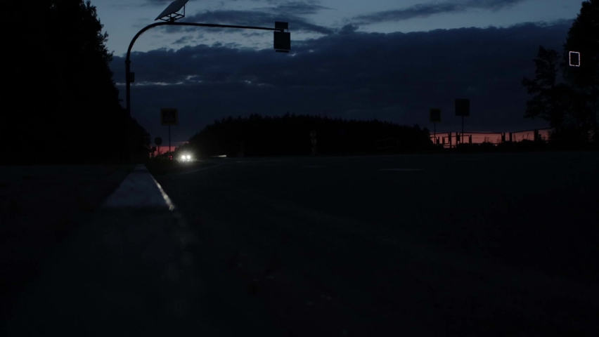 Traffic from cars on the motorway at night, in the background. Flashing pedestrian crossing across the road, transportation