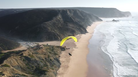 Cordoama Viewpoint. Vila do Bispo. Portugal. Epic scenery of a paraglider flying over azure ocean. Drone footage of pristine Portuguese coastal nature. High quality 4k footage