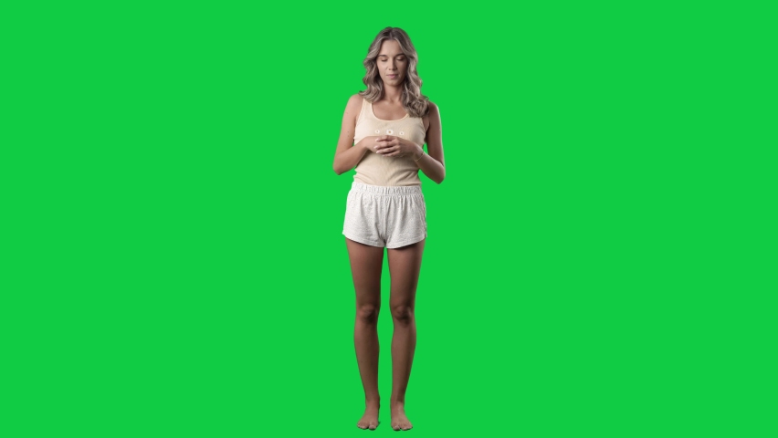 Young woman announcer in pajama showing and speaking while presenting. Full body on green screen chroma key background Royalty-Free Stock Footage #1080009269