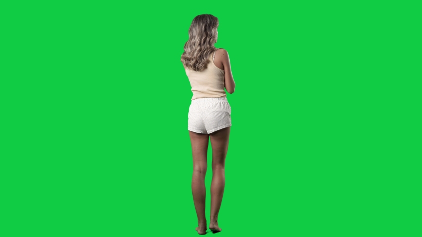 Back view of woman in sleep wear using touch screen interaction gestures. Full body on green screen chroma key background Royalty-Free Stock Footage #1080009299