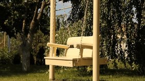 Beautiful wooden swing in the garden. White swing. Video