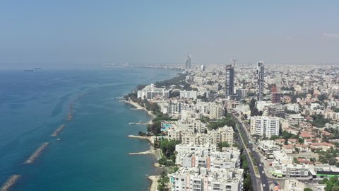 Aerial view Limassol Cyprus. Cityscape with high-rise buildings by the sea, the road on the shore, the waves crash against the shoreline.