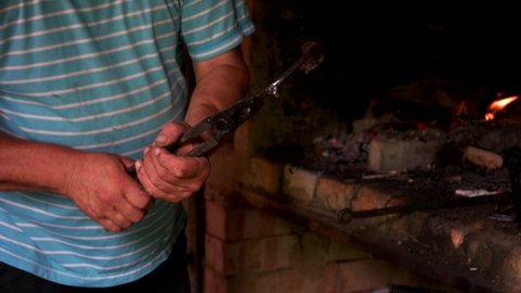 Blacksmith holding hot horseshoe with pliers.