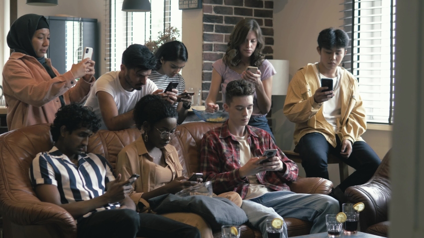Multiracial young people student group using gadgets smartphones, happy diverse female male users obsessed with modern technology devices holding phones, tech addiction concept | Shutterstock HD Video #1080014282