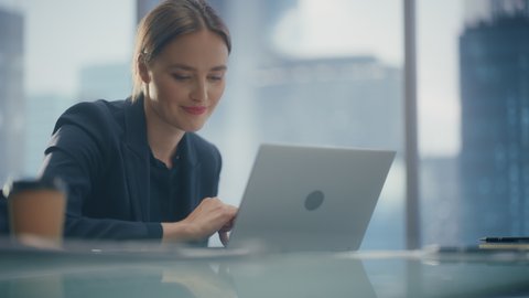 Close Up Low Angle Portrait of a Beautiful Businesswoman Working on Laptop in Open Office, Confident Female CEO Analyze Financial Projects. Manager Smile at Work while Using Social Media.