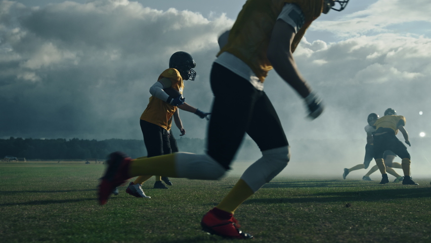American Football Field Two Teams Compete: Successful Player Jumping Over Defense Running to Score Touchdown Points. Professional Athletes Compete for the Ball, Tackle, Fight for Championship Victory Royalty-Free Stock Footage #1080022157