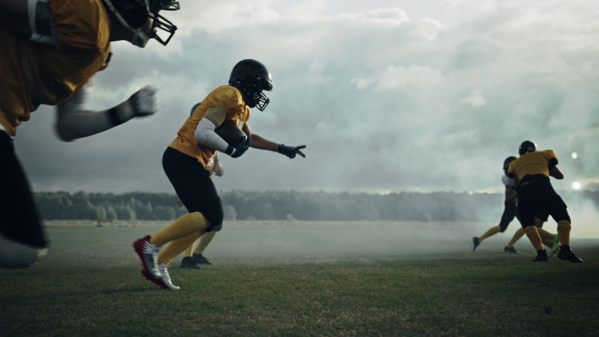 American Football Field Two Teams Play: Successful Player Jumping Over Defense Running to Score Touchdown Points. Professional Athletes Compete for the Ball, Fight for Victory. Dramatic Slow Motion Royalty-Free Stock Footage #1080022163