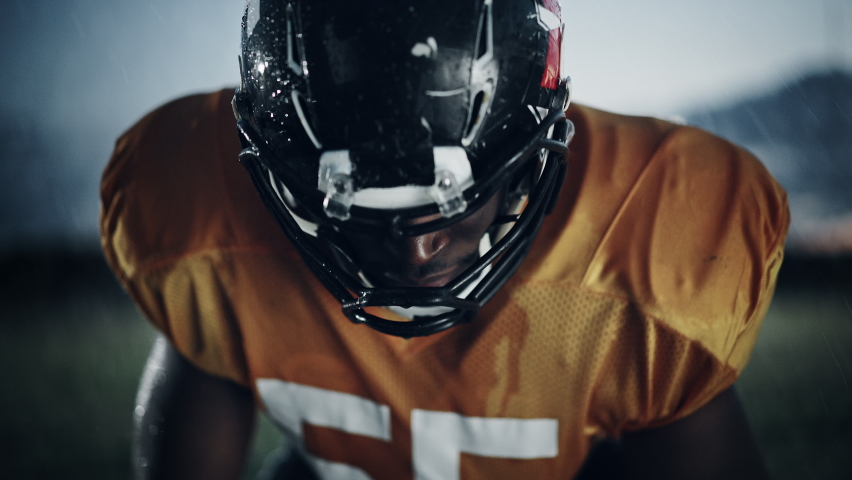 American Football: Professional African-American Player Looking at Camera. Hero Athlete Ready to Win the Championship. Determination, Skill, Power. Dramatic Portrait, Cinematic Zoom In Shot Royalty-Free Stock Footage #1080022214