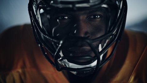 American Football: Professional African-American Player Looking at Camera. Hero Athlete Ready to Win the Championship. Determination, Skill, Power. Dramatic Portrait, Cinematic Zoom In Shot