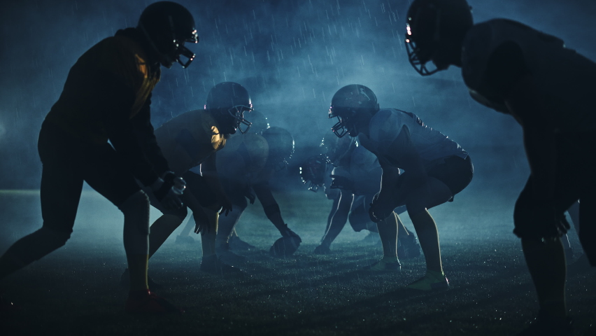 American Football Field Two Teams Compete: Players Pass and Run Attacking to Score Touchdown Points. Cinematic Rainy Night with Athlete Silhouettes Fight for the Ball in Dramatic Fogey Slow Motion Royalty-Free Stock Footage #1080022232