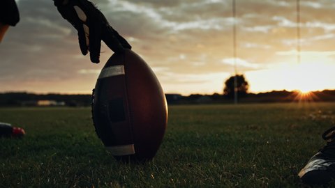Cinematic American Football Kickoff Game Start. Static Close-up of Ball Being Kicked by the Professional Player. Gates Goal Kick. Successful Team Wins Championship. Stylish Slow Motion Shot