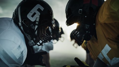 American Football Game Start Teams Ready: Close-up Portrait of Two Professional Players, Aggressive Face-off. Competitive Warriors Full of Brutal Energy, Power, Skill. Dramatic Stare. Cinematic Shot