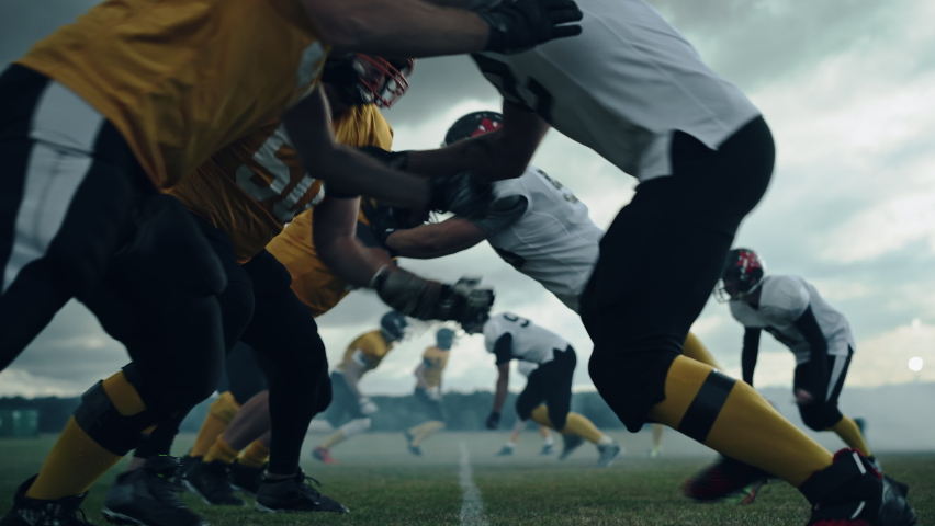 American Football Championship Start Teams Ready: Professional Players, Aggressive Face-off, Start Pushing, Tackling. Competition Full of Brutal Energy, Skill. Cinematic Slow Motion. Dramatic Sport