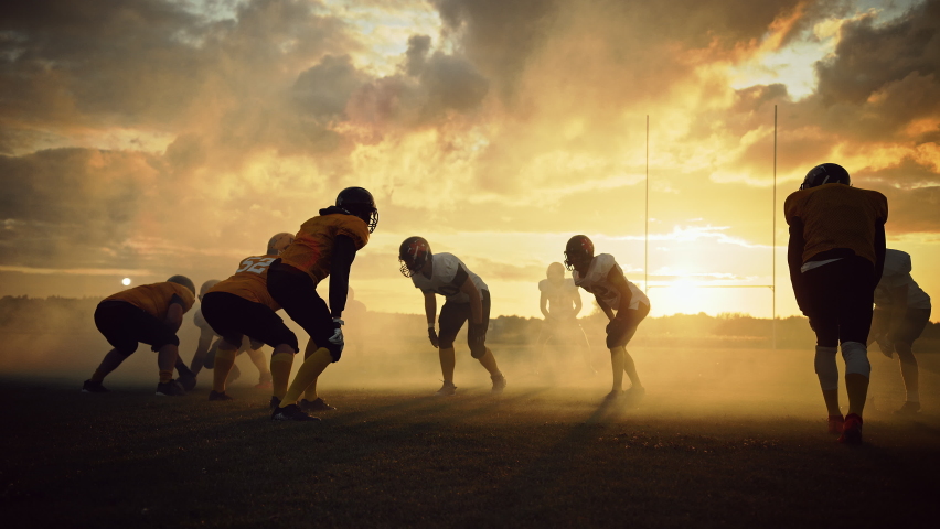 American Football Field Two Teams Play: Successful Player Running to Score Touchdown Points. Professional Athletes Compete for the Ball, Tackle, Fight for Victory. Dramatic Golden Hour, Slow Motion Royalty-Free Stock Footage #1080022394