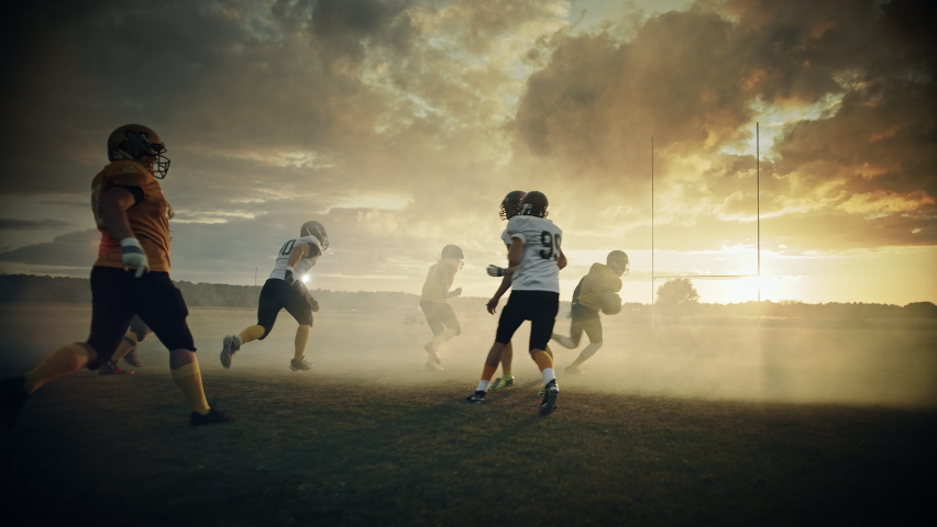 American Football Field Two Teams Play: Successful Player Running to Score Touchdown Points. Professional Athletes Compete for the Ball, Tackle, Fight for Victory. Dramatic Golden Hour, Slow Motion