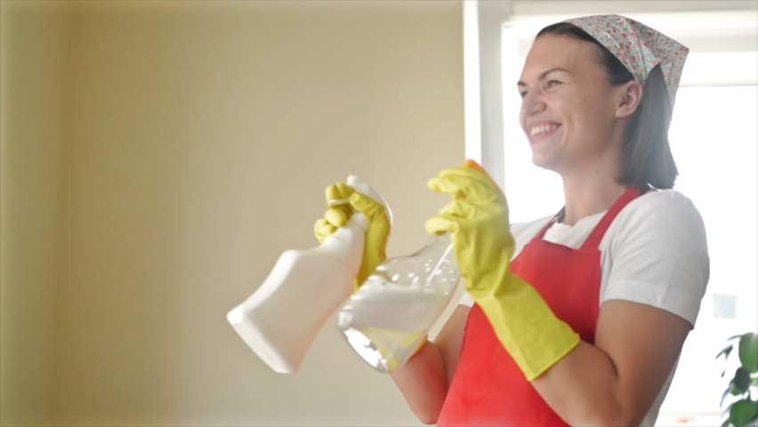 Tired of boring work, the housewife started a fun game with the Hand Sprayers. | Shutterstock HD Video #1080026147