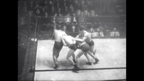 1940s: Four wrestlers brawl in ring. Wrestlers form headlock chain in ring.