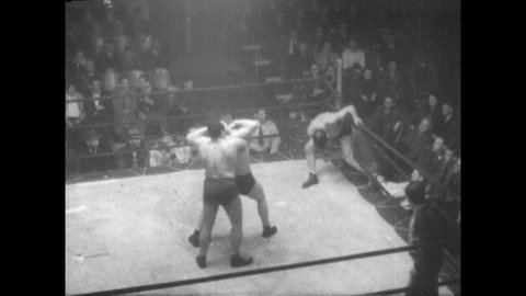1940s: Wrestler slaps and punches opponents. Wrestlers punch and brawl in ring.