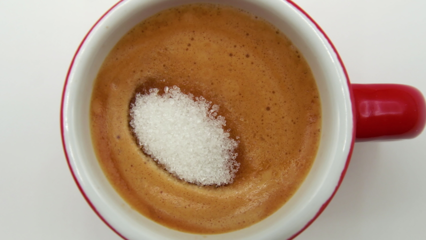 Macro.Close up of a teaspoon of sugar that dips gently into a cup of italian coffee.breakfast.coffee break.creamy coffee.unhealthy food | Shutterstock HD Video #1080029153
