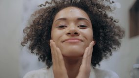Happy young female applying moisturizing cream on face, self-care routine, age - Powered by Shutterstock - Get 15% off with code: PIKWIZARD15