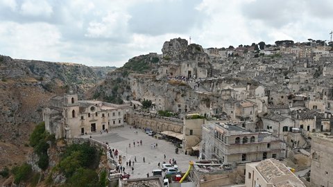 Matera, Basilicata, Italy. August 2021. Static footage with the church of San Pietro Caveoso on the left and the Rock Church of Santa Maria di Idris further up on the right. Cityscape of the stones.
