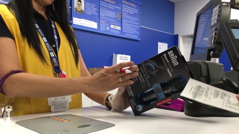 Coquitlam, BC, Canada - July 26, 2016 : Man returning beard trimmer at customer service counter inside Walmart store with 4k resolution
