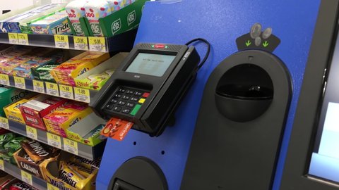 Coquitlam, BC, Canada - July 26, 2016 : The motion of man paying credit card for foods at self-check out counter inside Walmart store