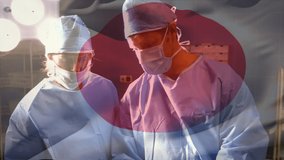 Animation of flag of japan waving over surgeons in operating theatre. global medicine, healthcare services during covid 19 pandemic concept digitally generated video.