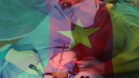 Animation of flag of cameroon waving over surgeons in operating theatre. global medicine, healthcare services during covid 19 pandemic concept digitally generated video.