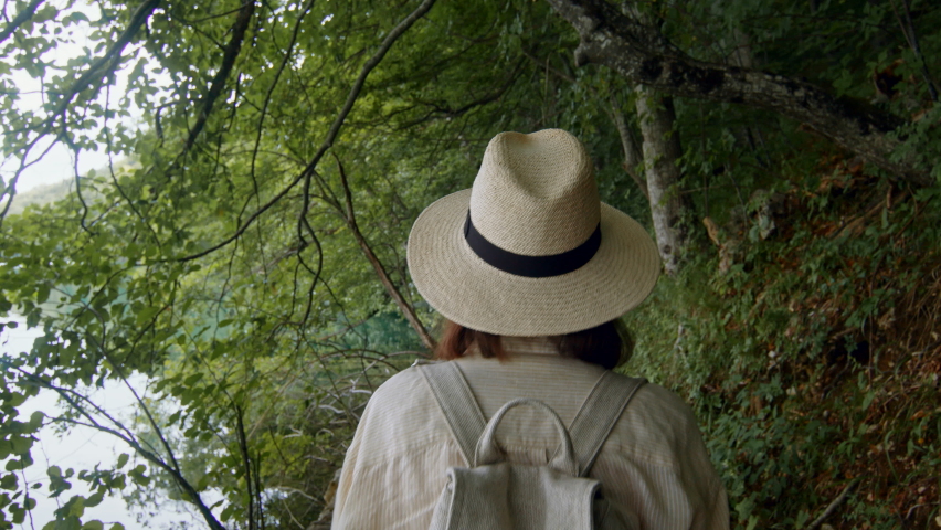 Young tourist walking along the path along the lake