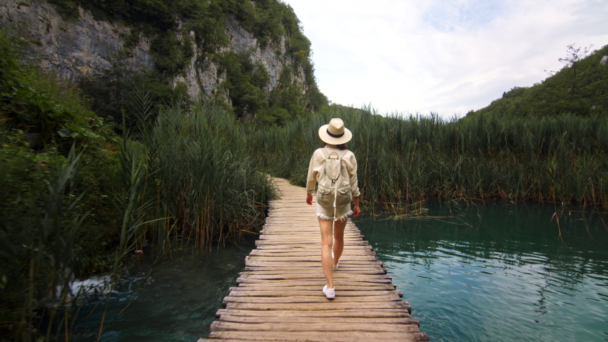 Young traveler walking along a wooden path