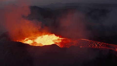 Fly above erupting active volcano. Close-up shot of splashing magmatic material in crater. Fagradalsfjall volcano. Iceland, 2021