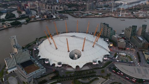 Slide and pan aerial footage of Millennium Dome. Futuristic entertaining facility on south bank of River Thames. London, UK