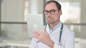 Middle Aged Doctor doing Video Chat on Digital Tablet