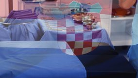 Animation of flag of croatia waving over surgeon preparing to operation. global medicine, healthcare services during covid 19 pandemic concept digitally generated video.