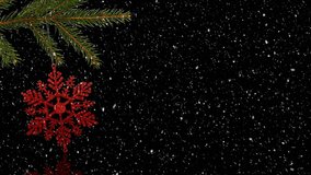 Animation of snow falling over red christmas decoration on christmas tree over black background. christmas, tradition and celebration concept digitally generated video.